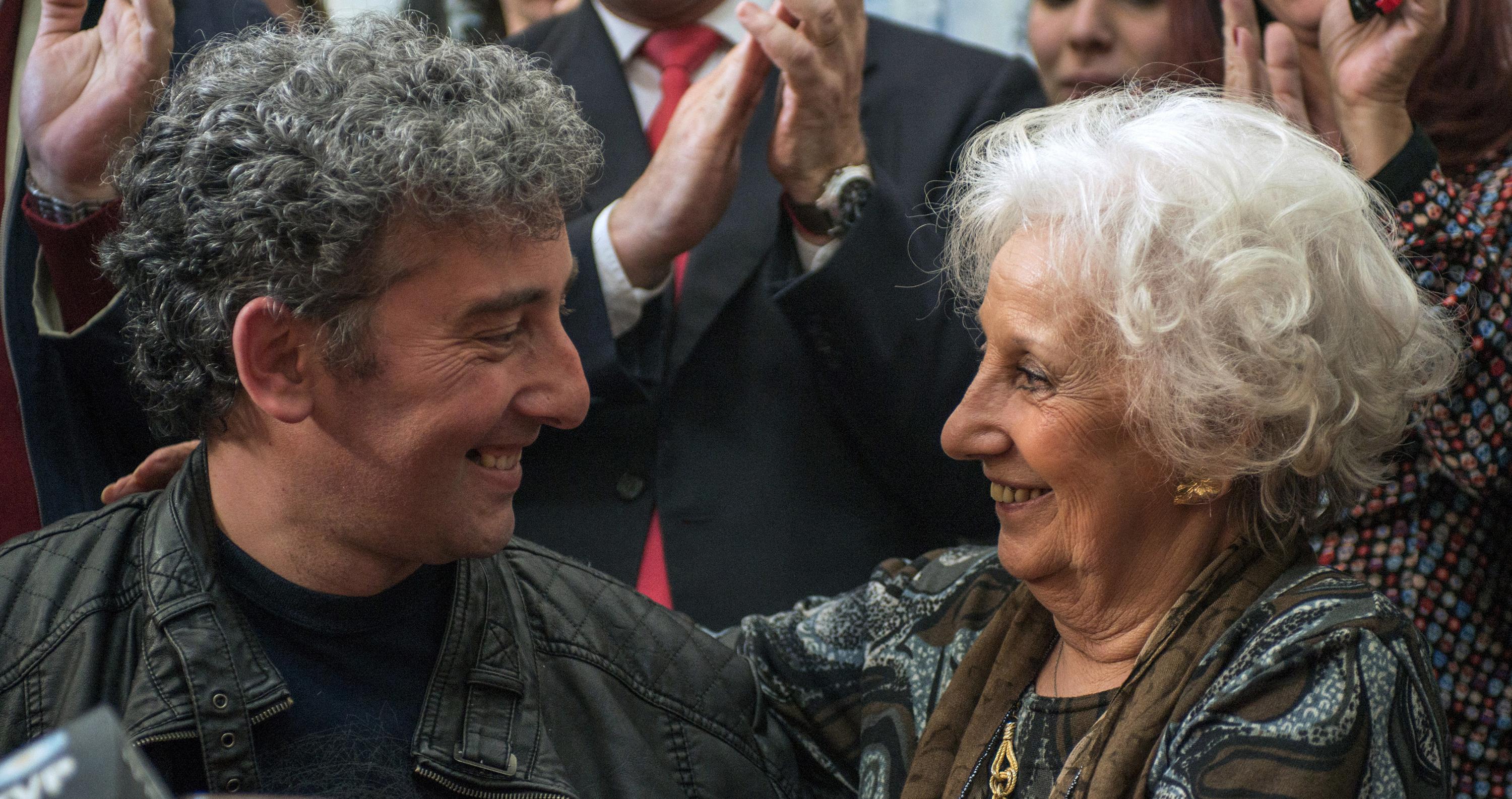 Estela de Carlotto (derecha), presidenta de las Abuelas de Plaza de Mayo, asociación de búsqueda para reunir a bebés robados durante el régimen militar (1976-1983) con sus padres biológicos o familiares, abraza el 8 de agosto de 2014 a su nieto Guido, hijo de su hija Laura, desaparecida en 1976. Foto de El Faro: Leo La Valle/AFP.