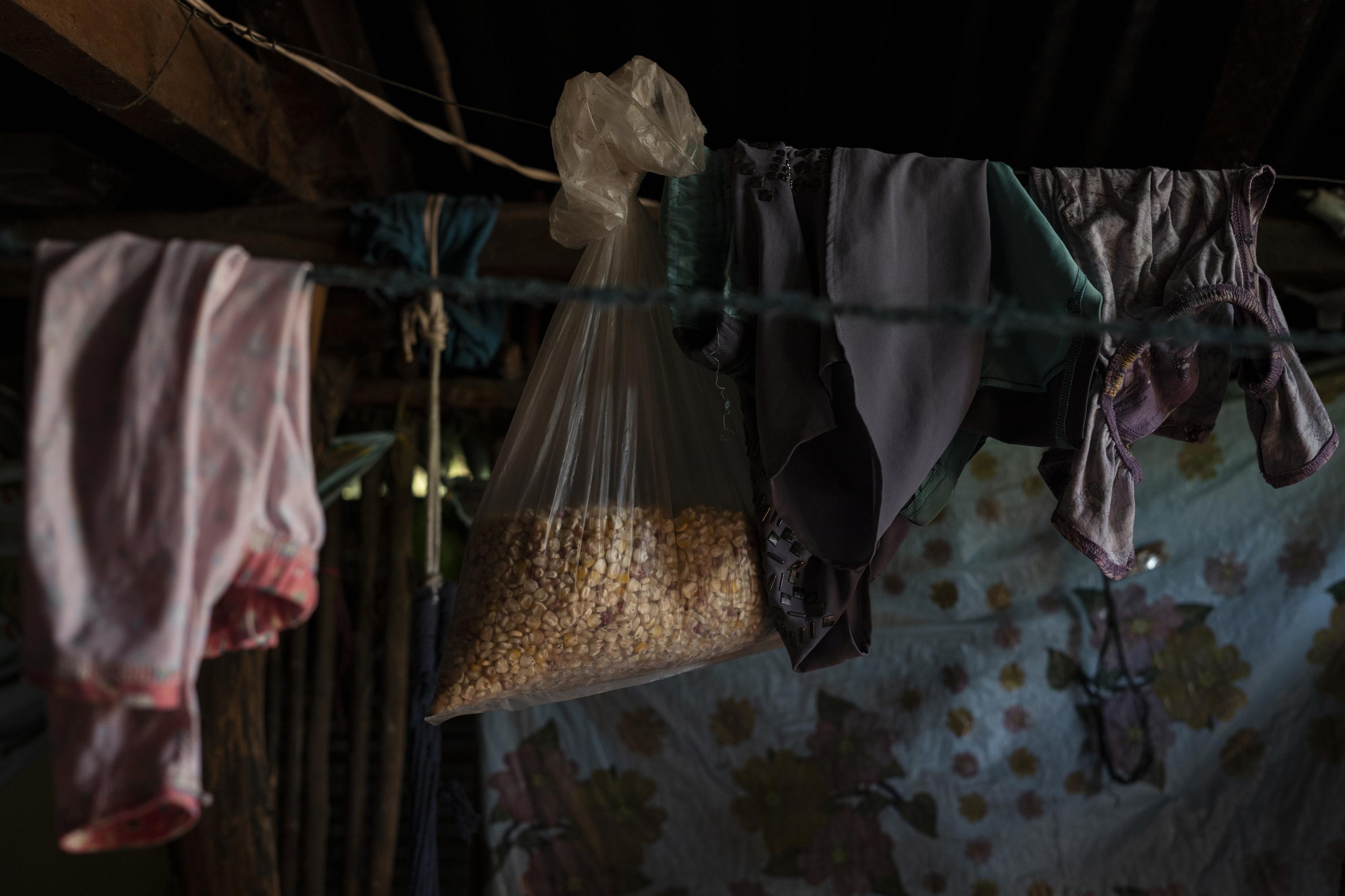 Nora Méndez almacena lo poco que le queda de su cosecha en su pequeña vivienda de lámina, en el cantón Valle Grande, del municipio de San Simón, departamento de Morazán. Nora ocupa su reserva de maíz para preparar las tortillas con las que se alimentan tres personas. Su familia come dos veces al día Foto de El Faro: Víctor Peña. 