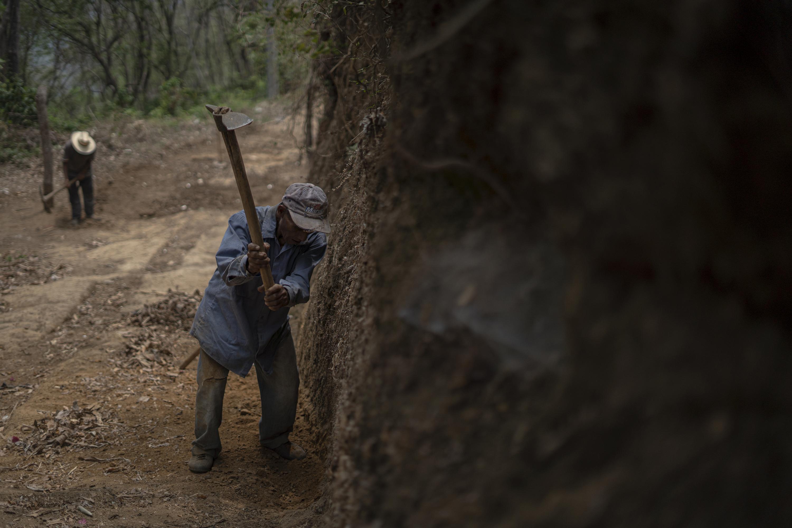 Vicente Mendoza, 78, pictured in the background, and Juan García Saldaña, 72, repair one of the roads leading to the community of El Jícaro Centro, in the municipality of Tacuba. Both work as volunteers, spending long hours swinging pickaxes and moving dirt with shovels to prevent the rain from flooding the road. Vicente was once a leader in the community, helping to manage the area’s electrical infrastructure projects. Now, he contributes as much as his age will allow. “I always watch Channel 10,” Vicente says, referring to the government-run television station. “All they ever talk about are wonderful things, but none of those wonders ever reach us here.”