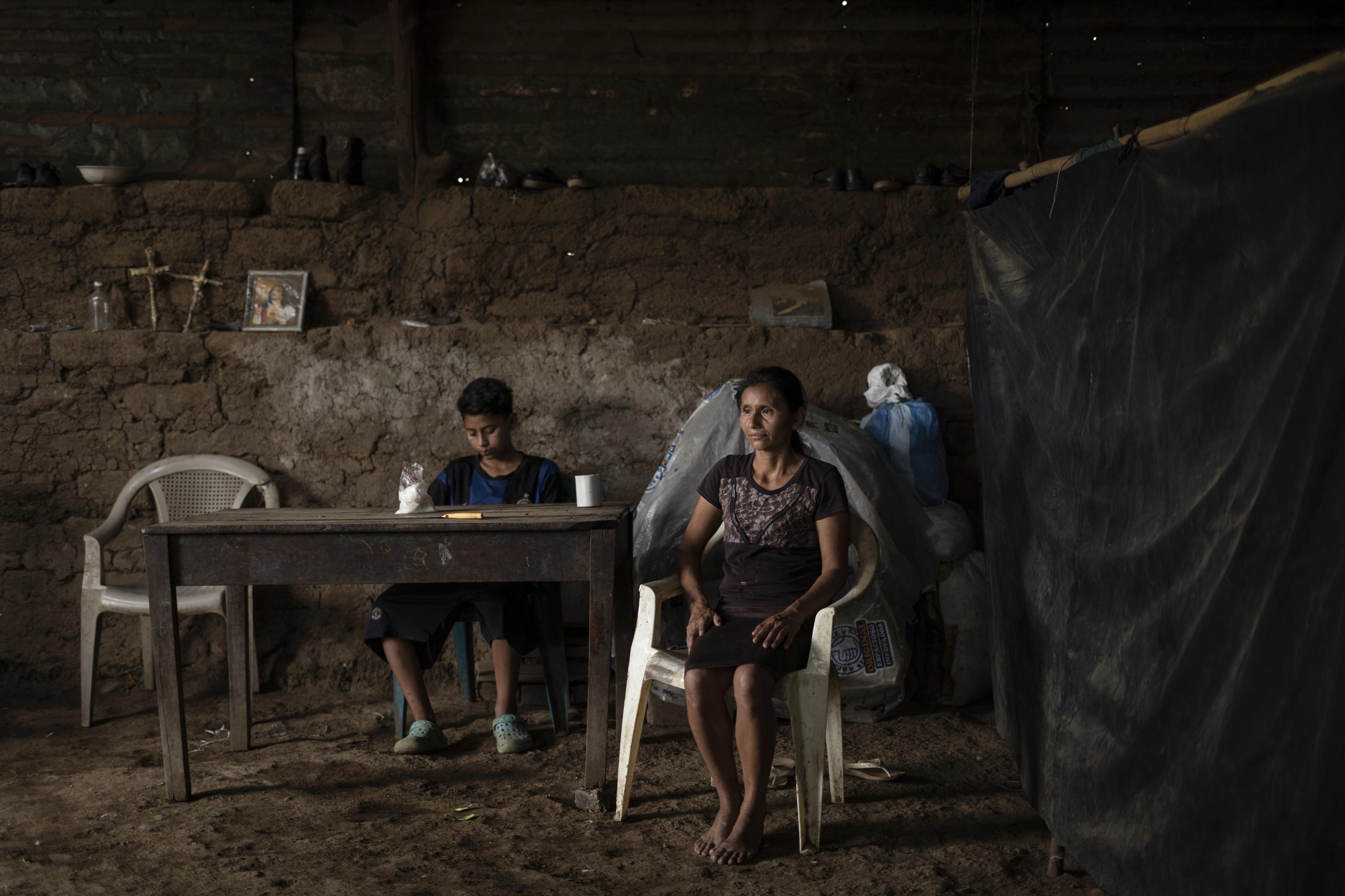 Celia Herminia López, 42, has been left to care for her grandson and five children alone since April 2, 2017, when gang members murdered her husband. On the Sunday morning he was killed, Aquilino Mendoza was returning from town after negotiating the use of some plots of land for the year’s planting. He was walking down the road that leads to El Jícaro, Tacuba —a territory that, up until then, had been under the control of MS-13— when he came across a group of men with guns in their hands. They had just murdered a young man, and their faces were uncovered. Aquilino knew them, and they knew him. After exchanging a few words, the men shot Aquilino and left his body lying in the dirt, according to Celia’s neighbors. After her husband’s death, Celia’s brothers began helping her with a little money every month, but in August 2022, they were both detained under the state of exception. Celia’s already precarious situation was thus compounded by both the criminal actions of the gangs and the repressive policies of the state. Sitting at the table next to Celia is her 13-year-old son Ronald, who has been suffering from headaches, fever, and vomiting for three days, but has not been able to see a doctor. In their home, they eat when they have food, and never more than two meals a day: mostly corn, some beans when someone gives them some as a gift, or when Celia manages to sell her vegetable pastries or finds some work at a farm. She doesn’t remember the last time she ate meat.