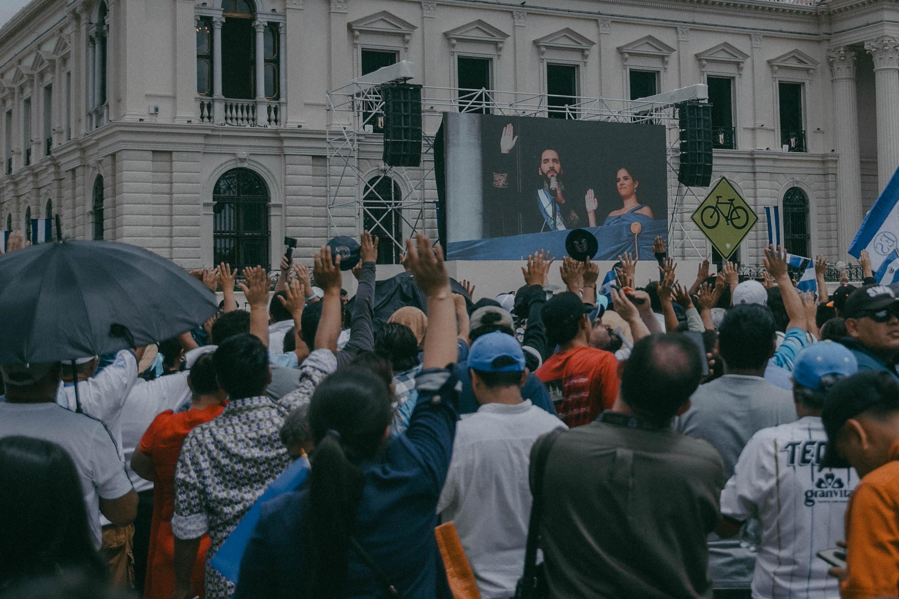 Al igual que en la toma de posesión del 2019, los asistentes al evento levantaron sus manos para jurar compromiso ante el presidente electo inconstitucionalmente, Nayib Bukele. Foto de El Faro: Carlos Barrera.