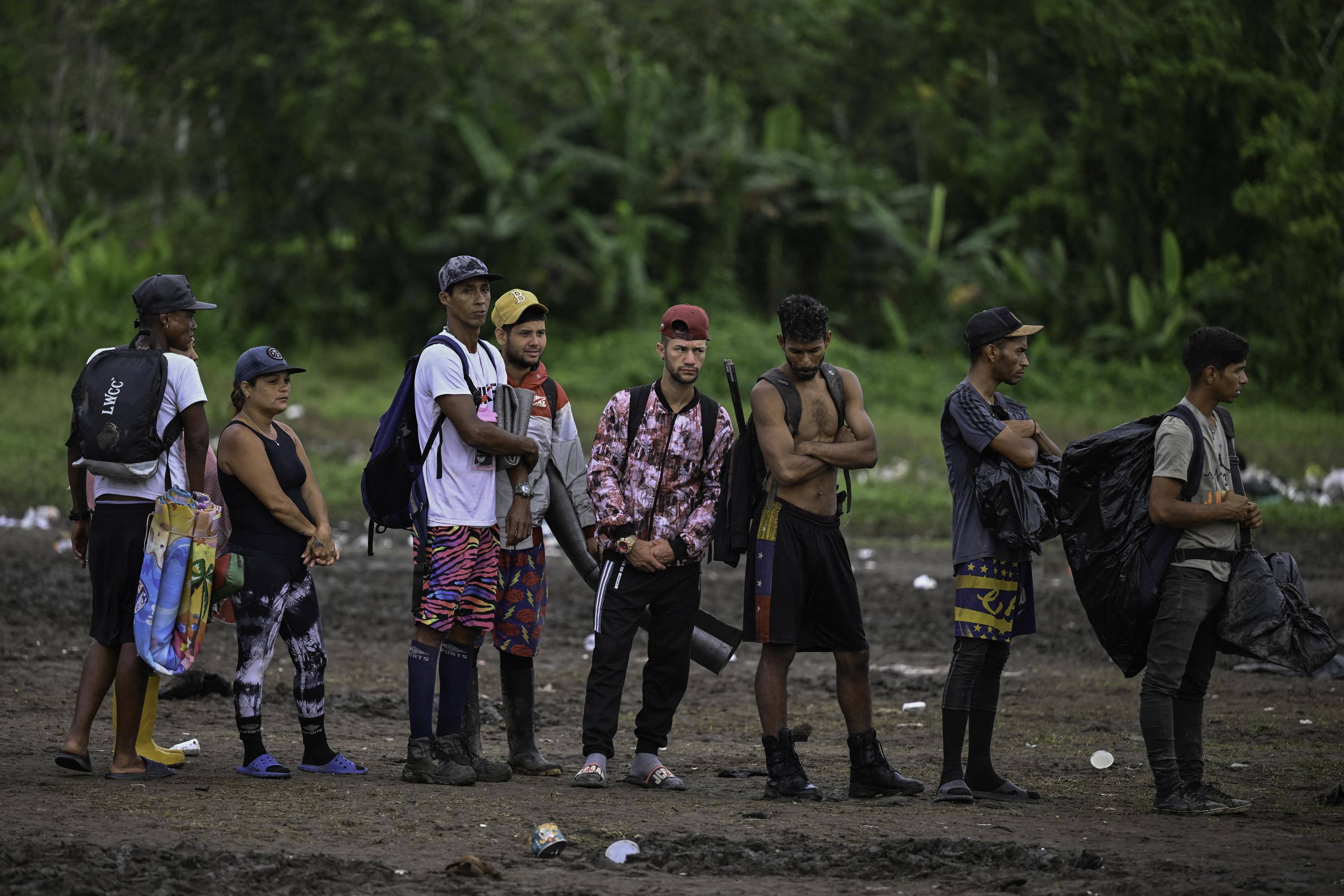 Migrantes venezolanos esperan ser registrados en un control fronterizo en la aldea de Canaán Membrillo, de la provincia de Darién en Panamá, el 13 de octubre de 2022. El viaje clandestino a través del Tapón del Darién suele durar cinco o seis días a merced de serpientes, pantanos y narcotraficantes. Foto de El Faro: Luis Acosta/AFP.